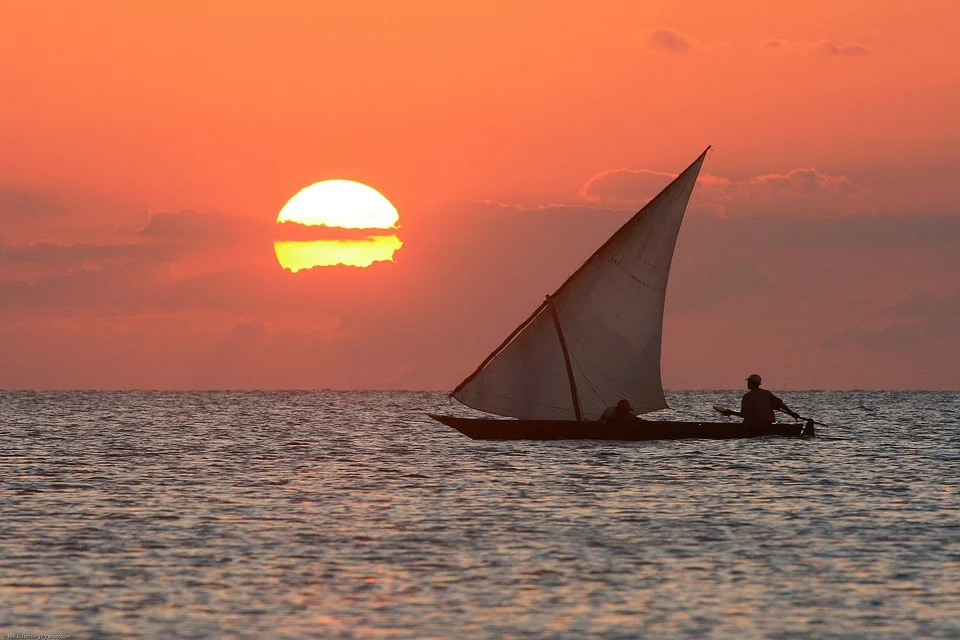 Stone Town Zanzibar seafront sunset — dhow boats waterfront golden light